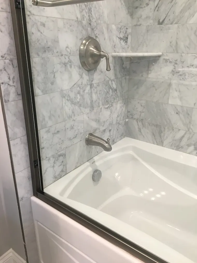 Marble tub surround with a new brushed-nickel shower valve and tub spout