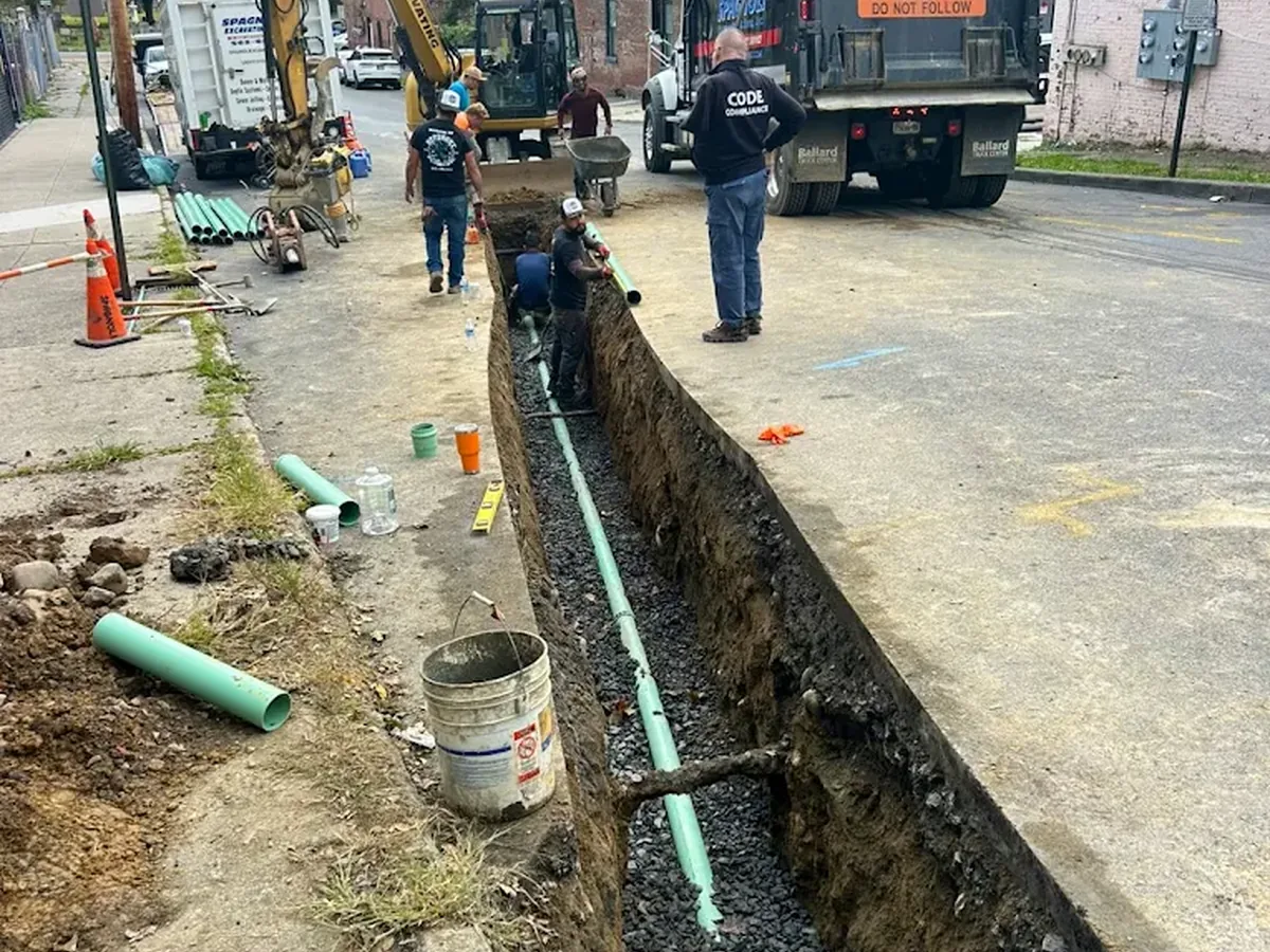 An Uppercut Plumbing crew replacing a main sewer line in an open street trench