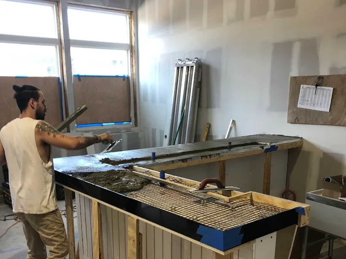 An Uppercut Plumbing technician roughing in plumbing for a new commercial bar build-out